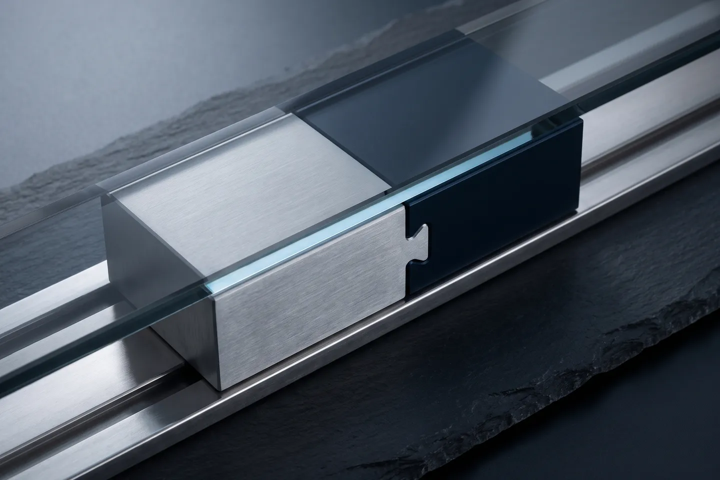 A silver block and a navy block interlock into one piece on a steel track